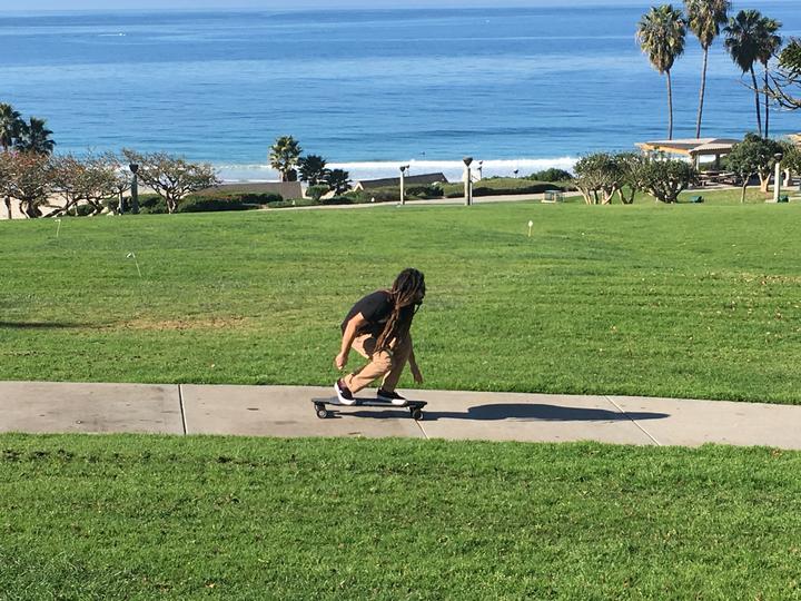 Man on electric longboard near the beach